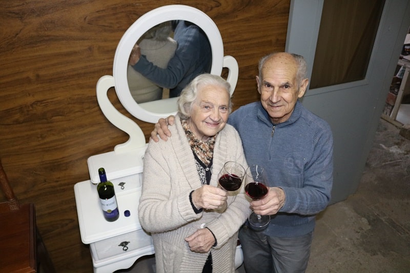 Casal de idosos juntos com taças de vinho em mãos